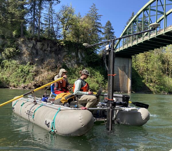 two men on a whitewater cataraft traverse green river water