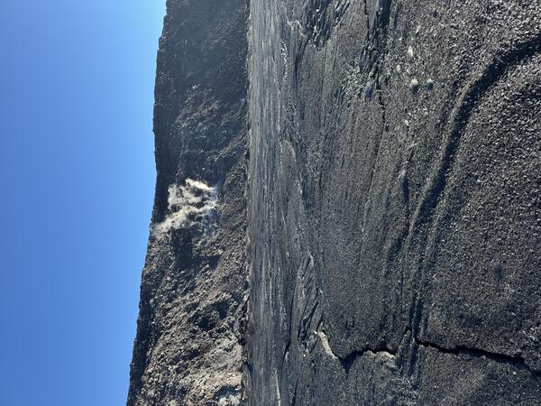 Color photograph of crater floor and steaming crater wall