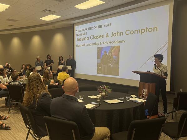 FALA teachers Jessina Clasen and John Compton were finalists for STEM Teacher of the Year in the 2026 Flagstaff STEMMY Awards. Photo of all finalists standing alongside a projector screen during the awards ceremony at Lowell Observatory..