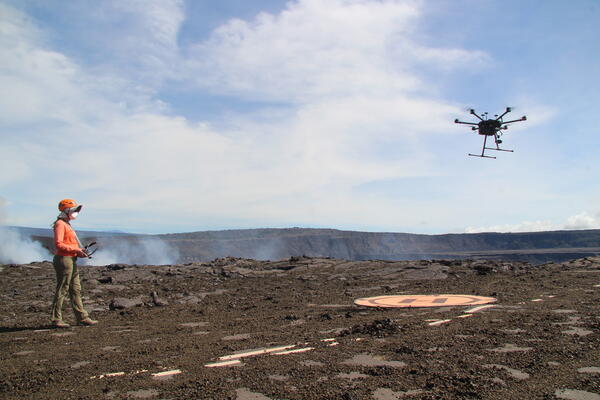 Color photograph of UAS pilot and UAS in air