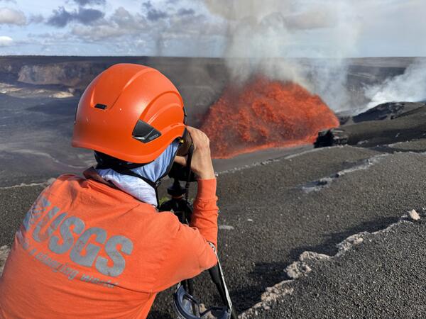 Color photograph of scientist monitoring eruption