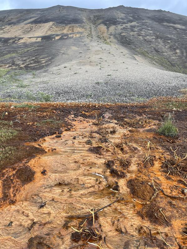 Orange stream with brown mountain in background.