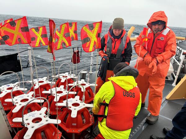 People on ship on ocean working on equipment