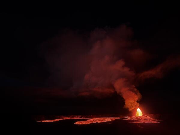 Color photograph of lava fountain and flows at night