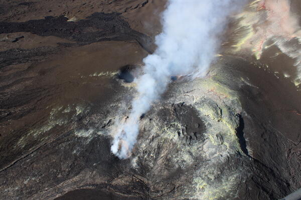 Color photograph of volcanic eruptive vents emitting a gas plume