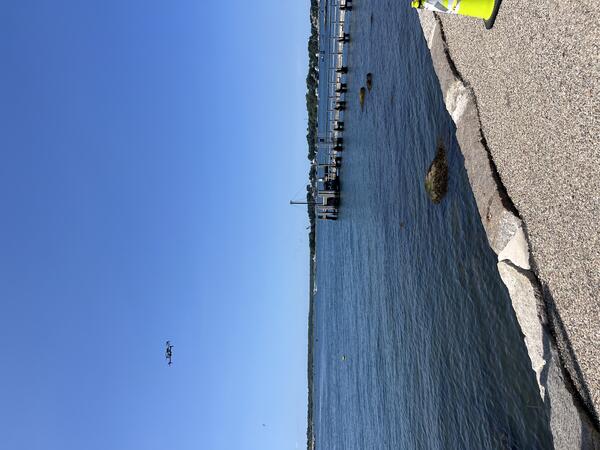 drone flying in the air over the ocean near the shore