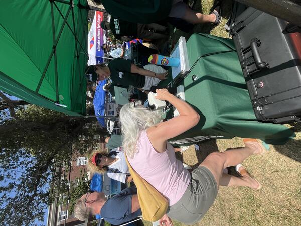 woman looking through microscope at outdoor event
