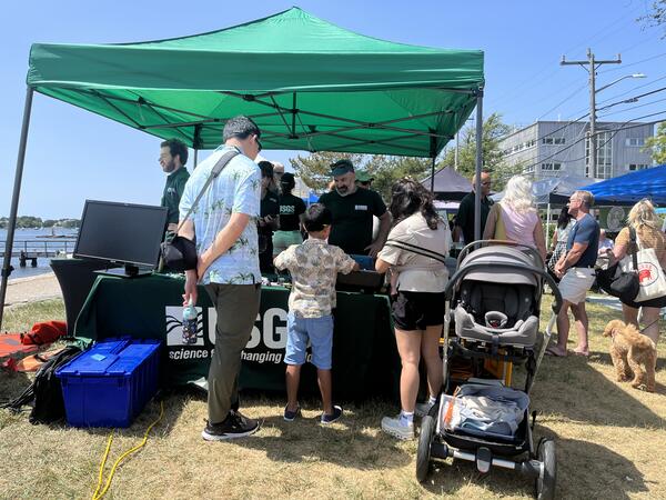 a family visiting a USGS booth outside