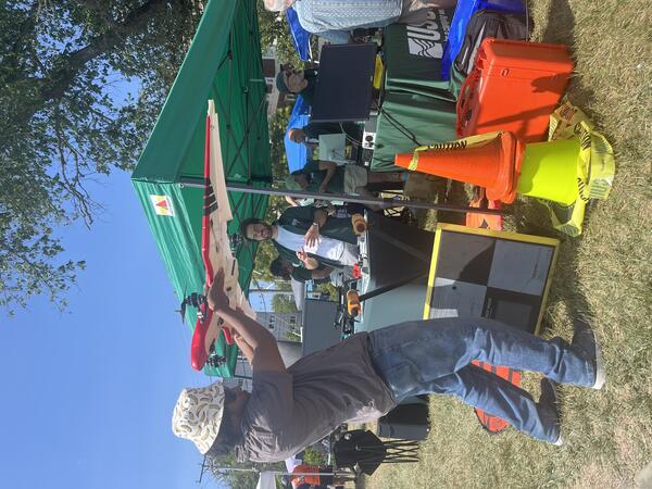 Person holding drone next to USGS booth and tent outside