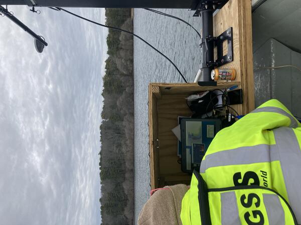 person sitting in front of a laptop on small boat on pond