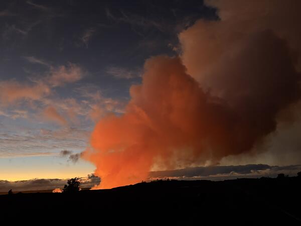 Color photograph of volcanic plume illuminated