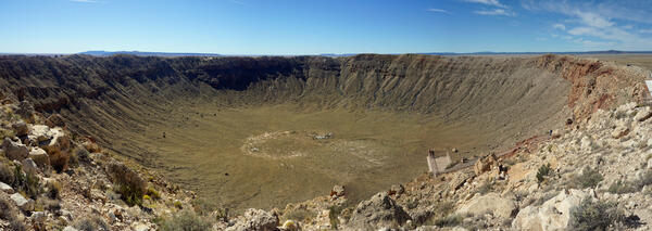 View of the Meteor Crater impact in northern Arizona: rocks ejected from a bowl-shaped feature, leaving an impact scar