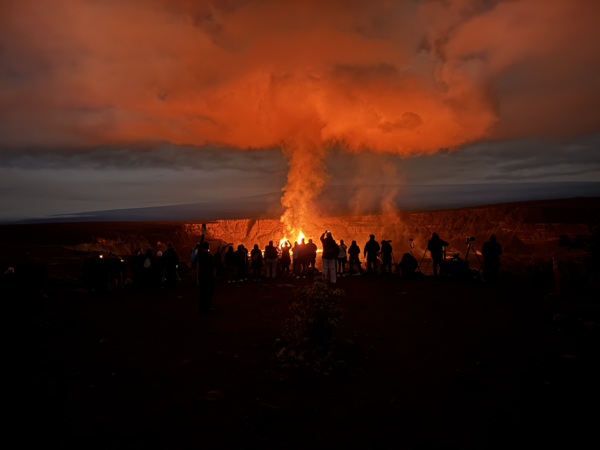 Color photograph of people watching volcanic eruption