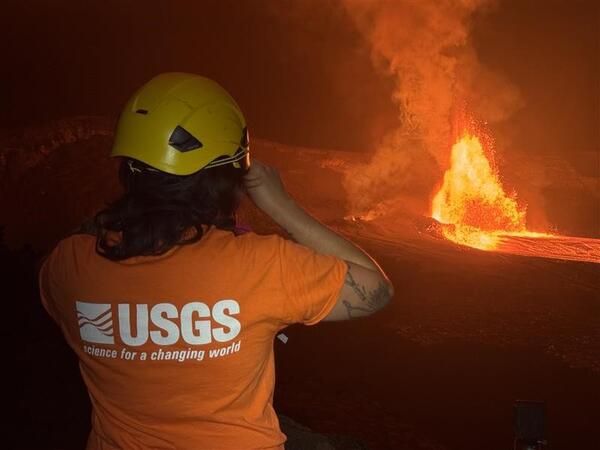 Color photograph of scientist monitoring a volcanic eruption