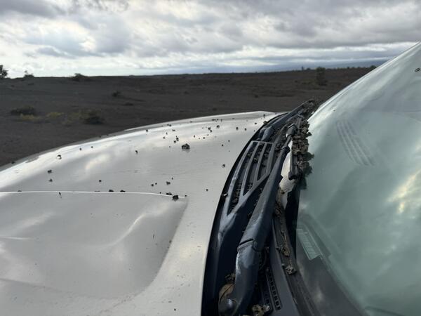 Color photograph of volcanic material on car