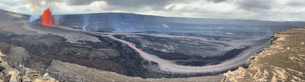 Color panoramic photograph of lava fountain and lava channel within volcanic crater