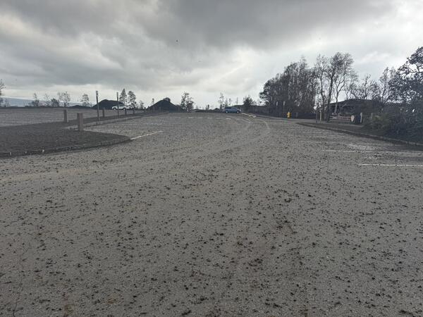 Color photograph of sparse volcanic fallout in parking log