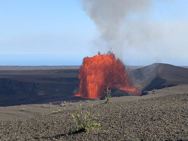 Orange and incandescent lava fountain erupting from a crater