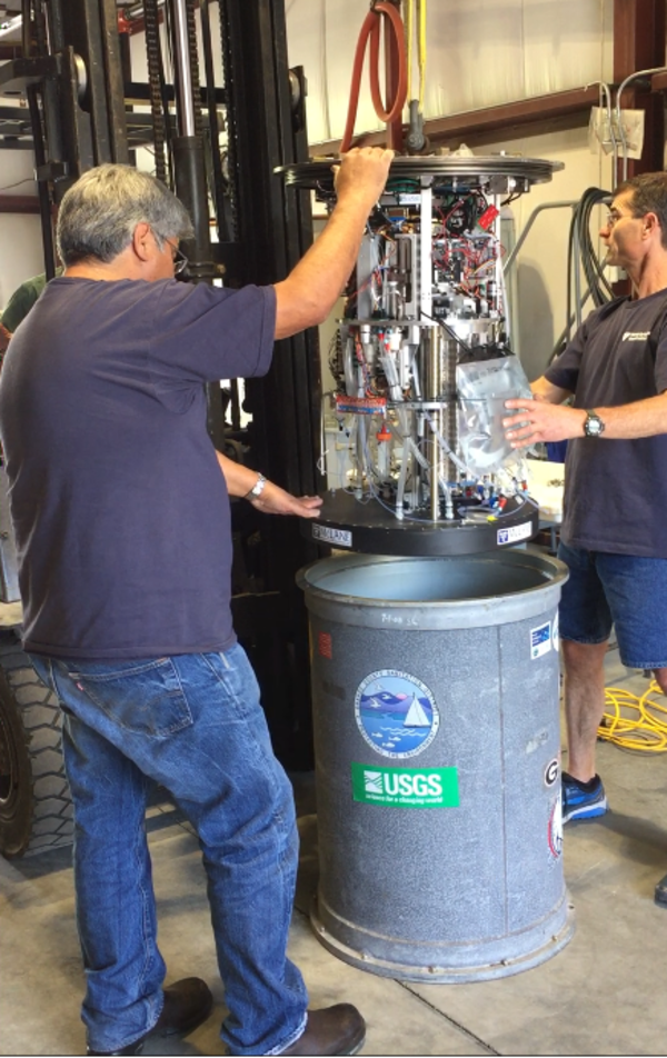 A robotic sampler is lowered into its metal housing. 