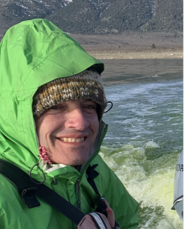 Geologist in green raincoat on boat