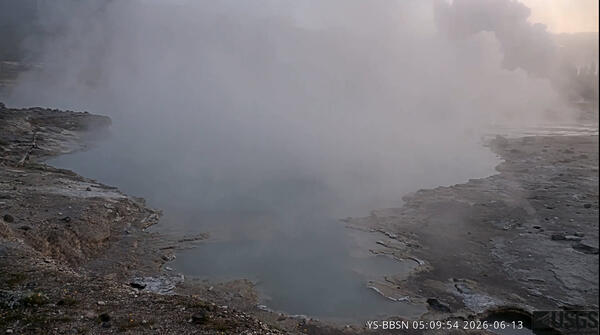 steaming blue pool in low-light dawn conditions with an explosive steam plume in the background
