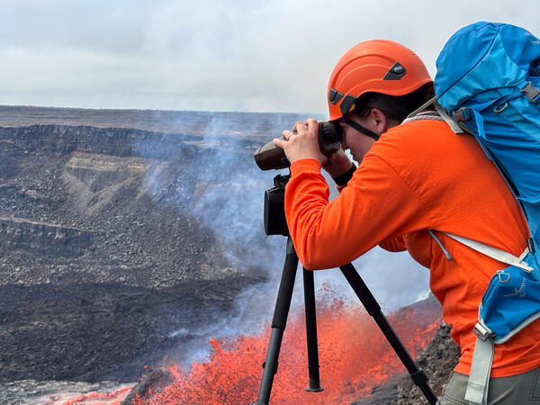 Color photograph of scientist monitoring volcanic eruption