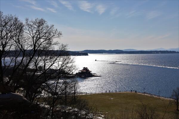 An overhead wide view of a lake with sun reflection.