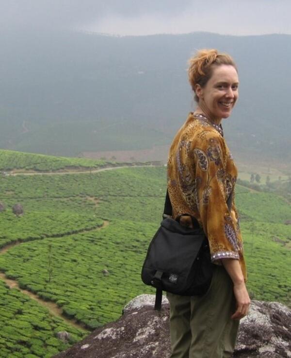 woman looking over her shoulder, terraced green fields in background