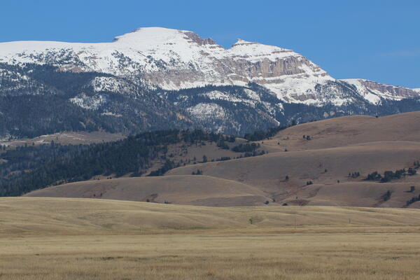 Prairie fading to hills with a snow-covered mountain in the background