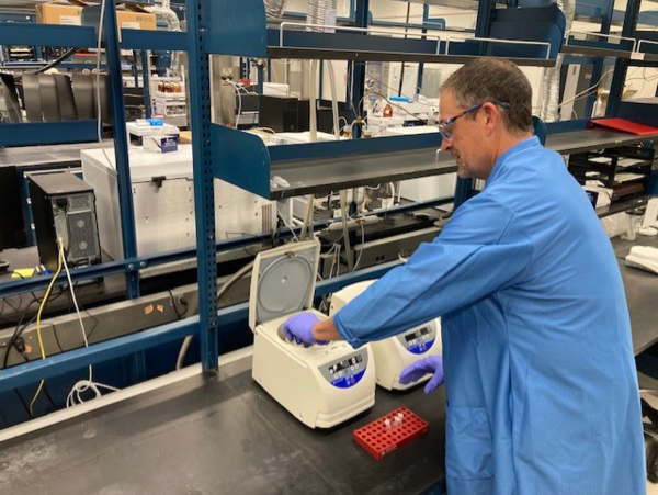 chemist putting samples into centerfuge