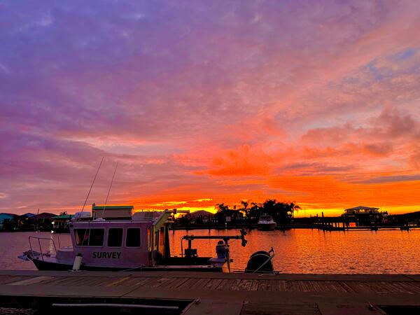 boat docked with sunset in background