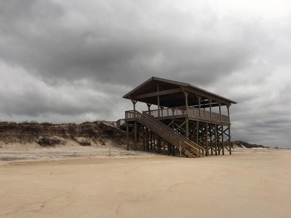 A pavilion or lookout deck that was previously on a dune, now with exposed support pilings after a series of storms