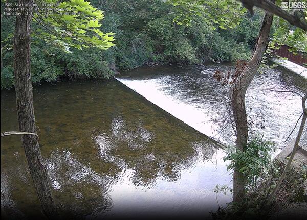 Looking downstream from a high vantage point as the river flows over a weir creating turbulence  downstream
