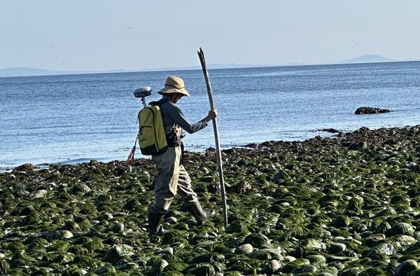 Picture of surveyor equipped with survey equipment during mapping mission