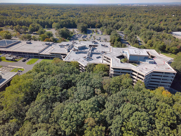 building and parking lot surrounded by trees