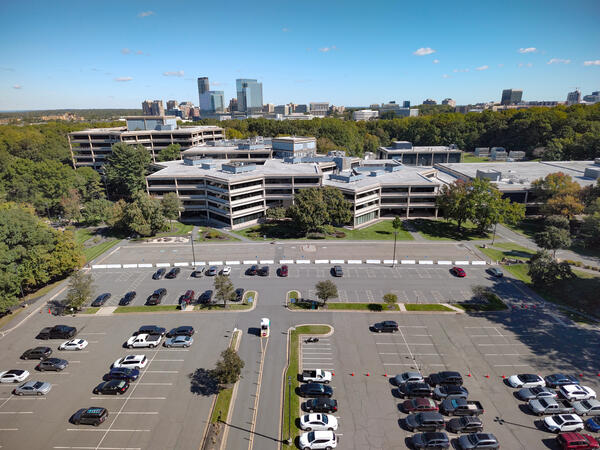 building and parking lot surrounded by trees
