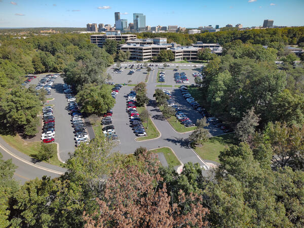 building and parking lot surrounded by trees