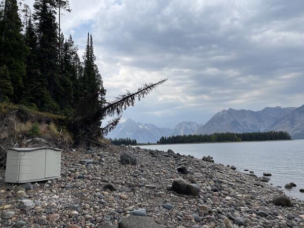 Plastic protective housing holding eDNA sampler on shore of lake