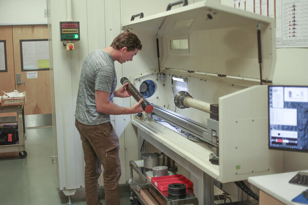Scientist placing a sediment core in the rotating x-ray computed tomography system