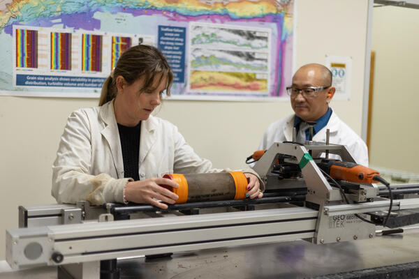 Scientists splitting a sediment core with the GeoTek core splitter