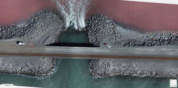 Bird's eye view of the Great Salt Lake's railroad causeway, where pink hypersaline waters of the north arm meet the blue-green waters of the south arm. The breach in the causeway allows water exchange between the two sides.