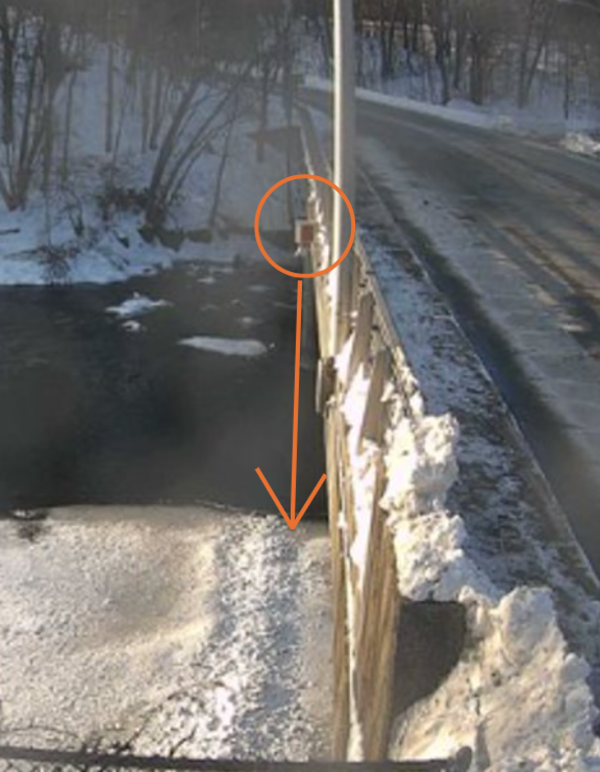 Partially frozen river flows under a USGS radar gage 