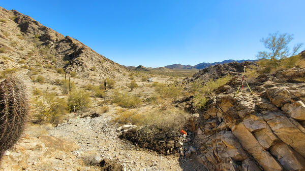 A rock outcropping with a survey tripod on top of it, looking out over the low desert in Cabeza Prieta NWR