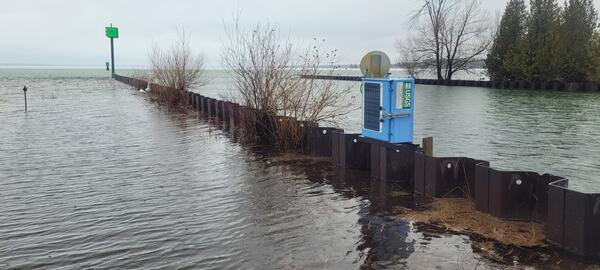 Blue USGS streamgage housing sits at outlet to lake