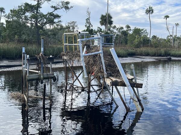 A streamgage station is damaged and partially dangling over the water after Hurricane Helene