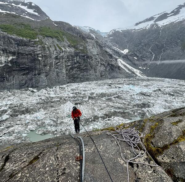 Person in a red jacket standing near a basin covered in ice.
