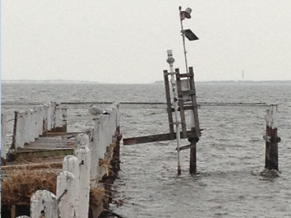 Looking out along a damaged pier at a wooden tower barely held upright by the scientific equipment it housed before the storm