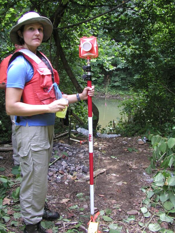 A scientist holds a device for measuring the cross section of the Roanoke River.