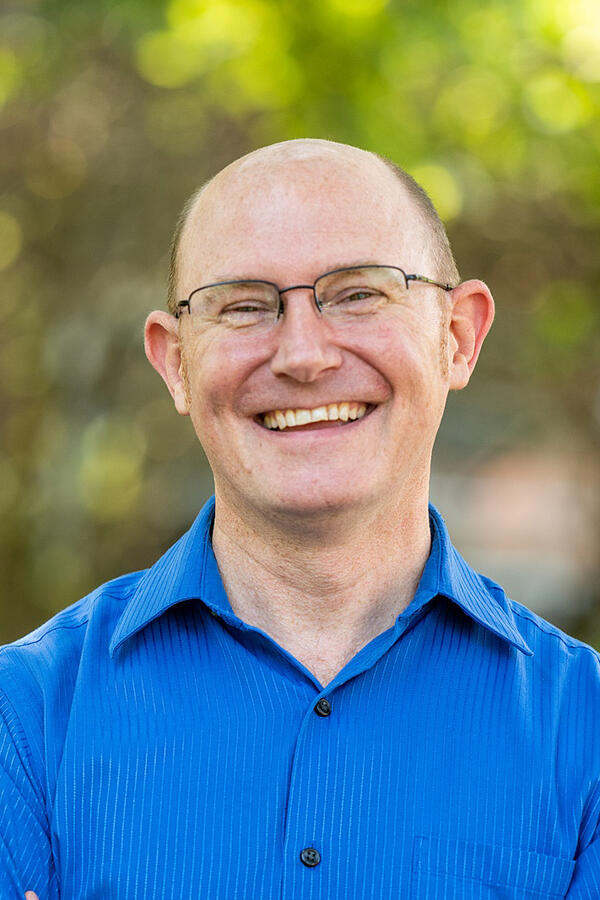 Man smiling in bright blue shirt      