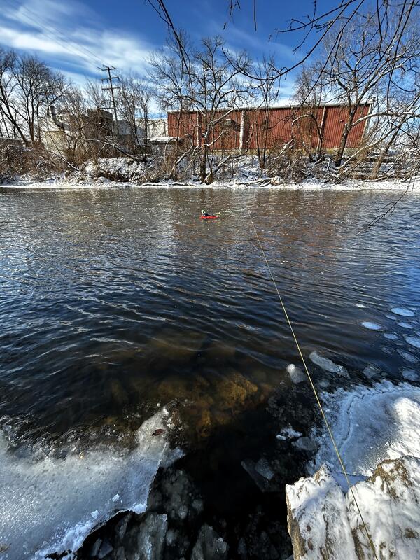 acoustic Doppler current profiler floats in middle of river attached to cable across on a winter day
